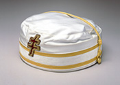 33rd Cap
A white cap, with no bill. With two gold thin stripes that circle the cap, a gold strap that goes over the cap, and decorated with a patriarchal cross.